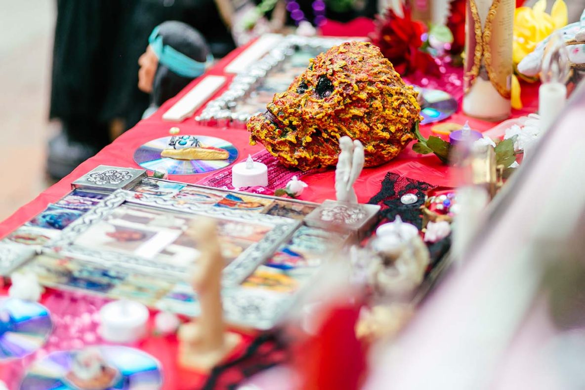 A decorative dog-shaped item made of small brown objects on a colorful table.