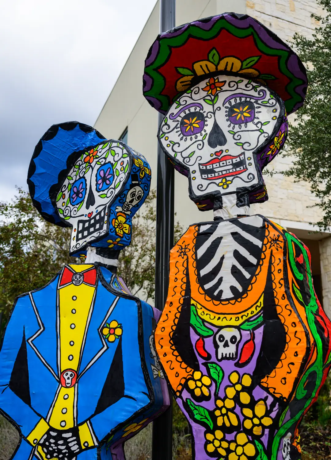 Colorful Catrín and Catrina skeleton figures dressed in traditional-inspired attire at Muertos Fest