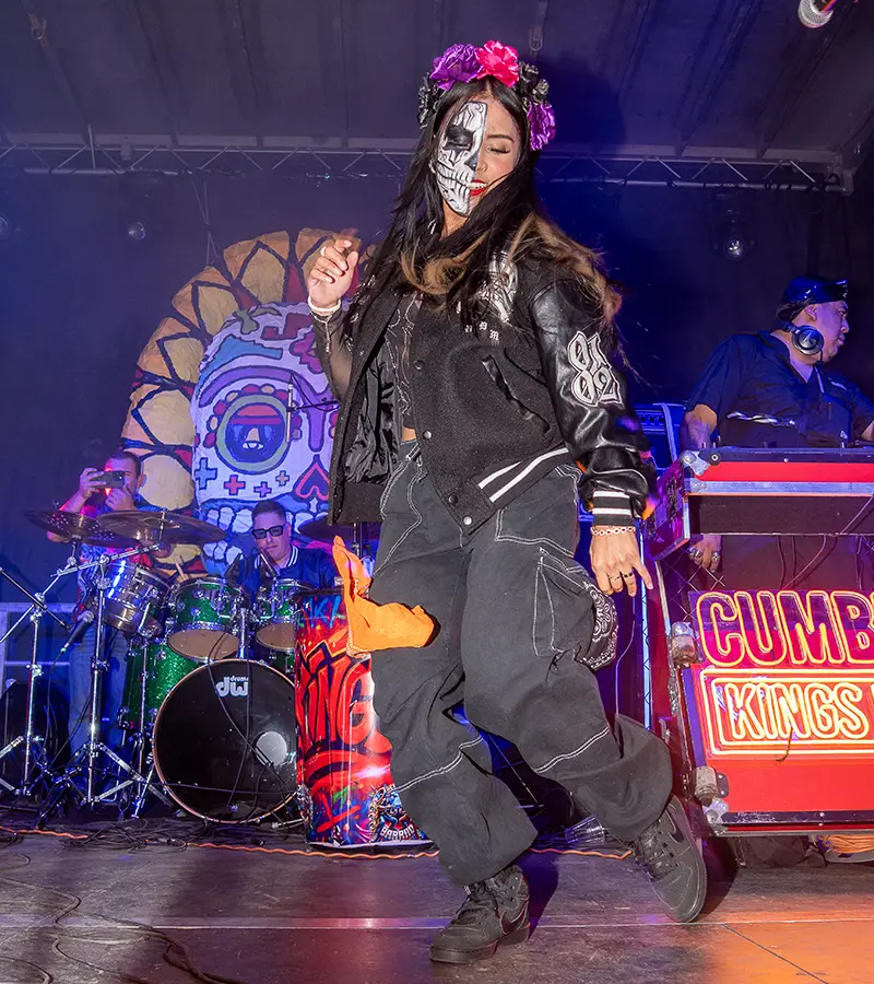 Female singer wearing a flower crown performing live on the Muertos Fest stage